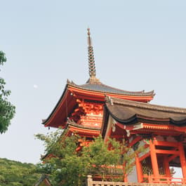 An orange temple in Japan against a clear blue sky taken by Erica Coble @filmandpixel