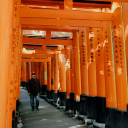 The iconic Fushimi Inari Shrine with a person walking through it taken by Erica Coble @filmandpixel