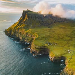 Looking at the Faroe Islands and Mulafossur Waterfall from above at sunset