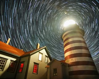David Johnson - timelapse photo of starts around a lighthouse