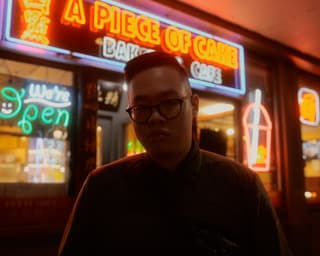Night time portrait of a person in front of neon lights in Seattle's Chinatown.