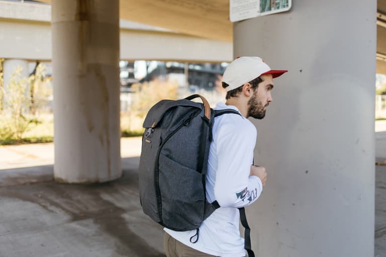 Peak Design Everyday Bag - Man walking down the streets with large grey backpack made for everyday use.