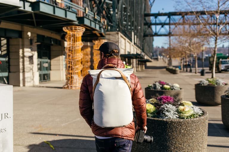Peak Design Everyday Totepack  - Man walking in Seattle with the bone-colored tote pack on his back.