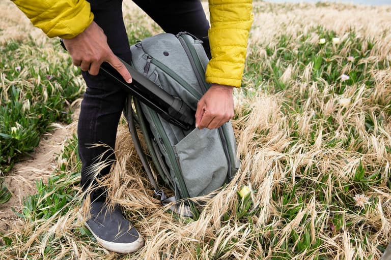 Peak Design Travel Tripod - Person putting tripod in a backpack.