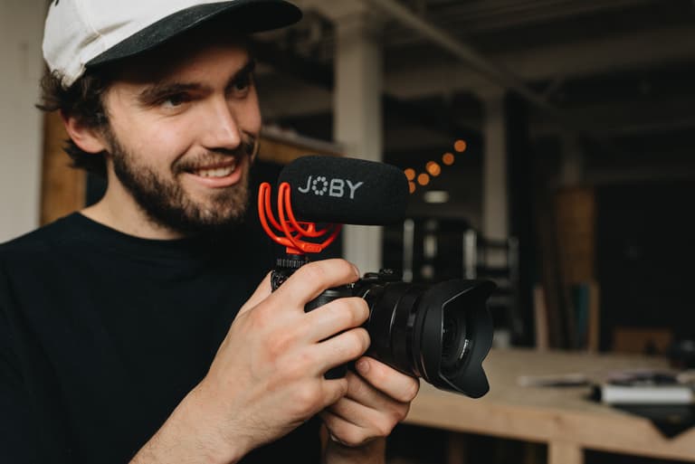 Man holding JOBY Wavo Vlogging Mic for an article - The Best Vlogging Cameras for YouTubers & Content Creators
