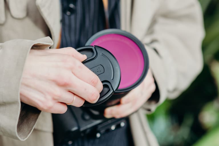 Woman putting a standard center pinch lens cap over the Moment Variable ND Filter