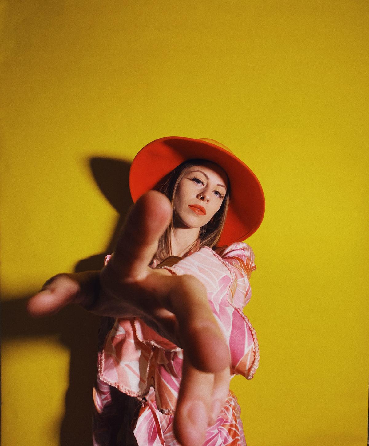 iPhone 11 - Portrait of young woman wearing pink robe and orange hat.