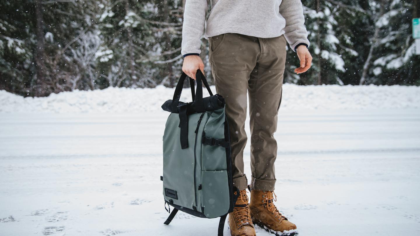 Wandrd Bag - Showcasing the bag with a man's bottom half of body with shoes in the snow.