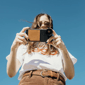 Woman holding a phone with a Moment Case and Lens