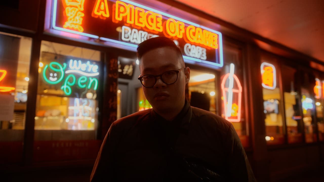 Night time portrait of a person in front of neon lights in Seattle's Chinatown.