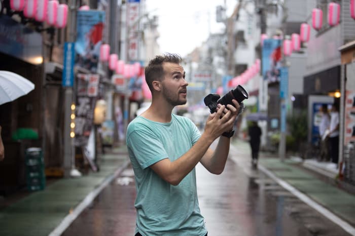 Jesse Driftwood shooting video in the middle of the street in Japan on a rainy day