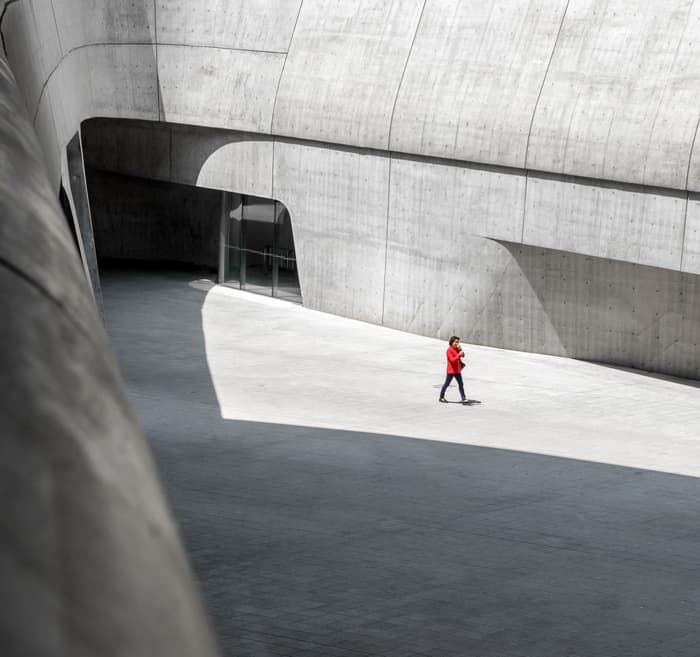 A person walks through the curving cement walls of the Dongdaemun Design Plaza in Seoul, Korea